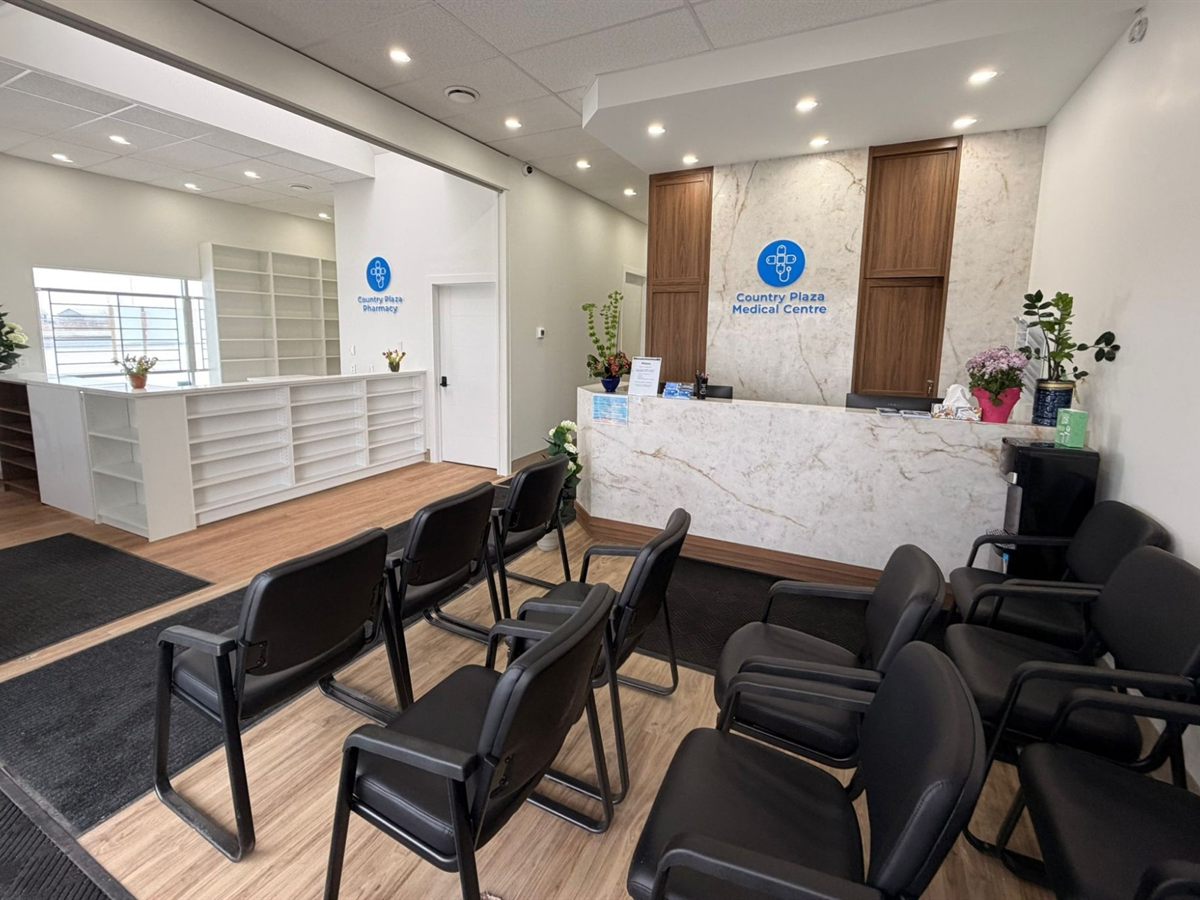 Completed reception area at Country Plaza Medical Centre, with a marble front desk, walnut joinery and the adjoining Country Plaza Pharmacy fit-out behind